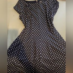 Navy blue polkadot dress with a flattering waist and high neckline